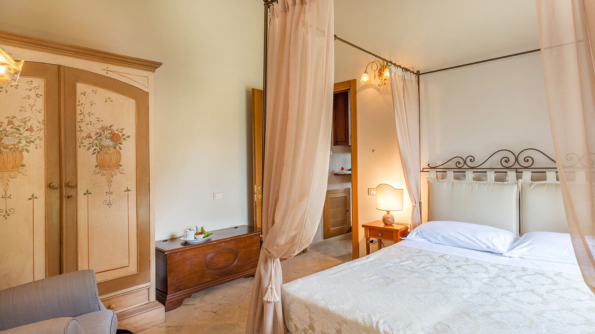 A bedroom with a bed, a nightstand, a dresser, and a wardrobe.