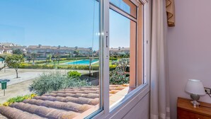 Ein Balkon mit Blick auf ein Schwimmbad und eine Wohngegend.