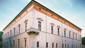 A large, rectangular building with a textured facade, multiple windows, and a prominent entrance with a decorative archway. - HOLIDAY RESIDENCE: sea and shopping within reach. (Lido degli Estensi)