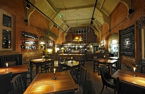 Enjoy a casual dining experience in our restaurant with tables for two to many, a bar area, and a chalkboard menu.