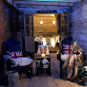 Relax in the charming Potting Shed, featuring a bathtub, armchairs, and a cozy atmosphere.