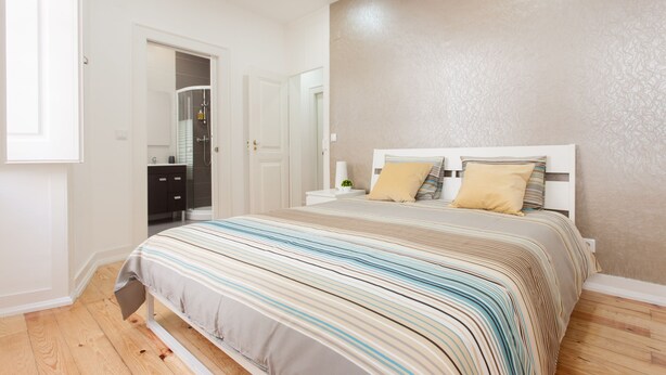 Un dormitorio con cama, mesita de noche y armario.