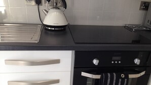 Une cuisine équipée d’une bouilloire, d’un grille-pain et d’un four encastré.