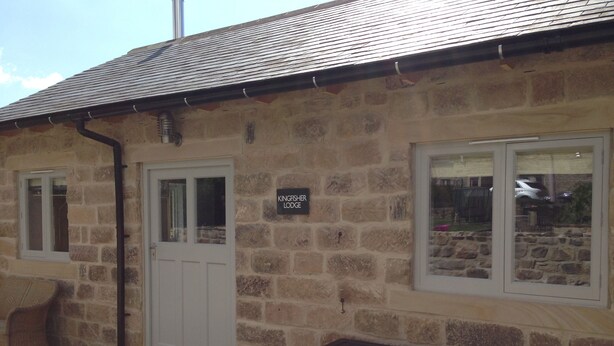 Un bâtiment en pierre sur lequel on peut lire l’inscription : « Kingfisher Lodge ».