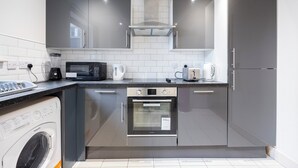 Ett modernt kök med vitvaror i rostfritt stål, en inbyggd ugn och en diskmaskin.