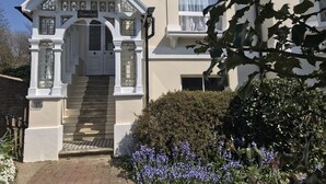Un edificio con facciata bianca, un piccolo portico con una porta in vetro e un cartello che riporta la scritta "Harborne Lodge".