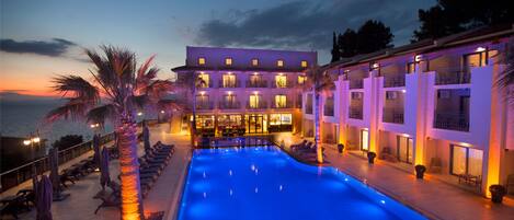 Vista frontal de la propiedad por la tarde o noche