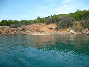 A coastal landscape with a clear view of the sea, rocky cliffs, and dense greenery. - Blue apartment Jadro island Rab (Barbat)