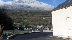 Una carretera que lleva a un edificio, con una montaña al fondo.