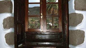 Eine Holztür mit Fenster, eingebaut in eine Steinmauer.
