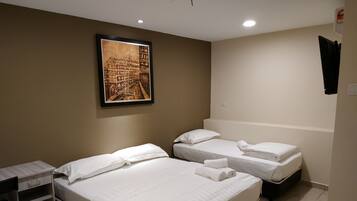 Quarto de hotel com duas camas, uma escrivaninha e um quadro pendurado na parede.