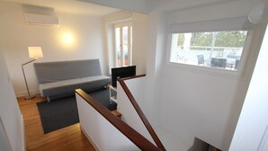 A room with a bed, a TV, a lamp, and a window. - OPO-APT 112-R Terrace apartment in city center. Soberb view on a huge terrace. (Porto)