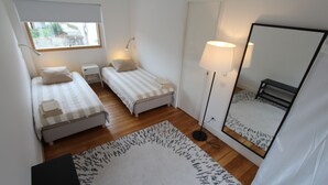 A small, clean room with two beds, a standing lamp, a mirror, and a window. - OPO-APT 112-R Terrace apartment in city center. Soberb view on a huge terrace. (Porto)