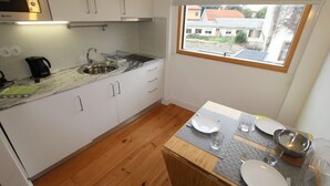 A compact kitchen with a sink, stove, and window overlooking a residential area. - OPO-APT 112-R Terrace apartment in city center. Soberb view on a huge terrace. (Porto)