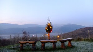 A bench area with a decorated tree and a view of distant mountains.