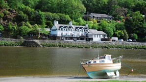 A boat named 'Joy' docked near a waterfront with a building in the background.