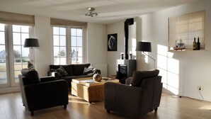 Una sala de estar con un sofá, sillones, una mesa de centro y una chimenea.