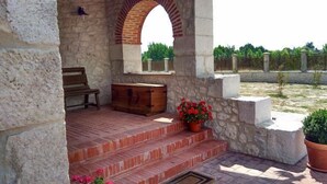 Un patio de piedra con escalones que conducen a un banco y un cofre de madera.