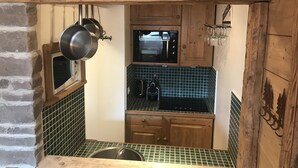 A kitchen with wooden cabinets, a microwave, and a stove.