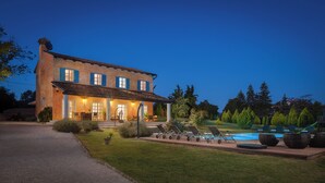 A two-story house with a patio and a swimming pool.