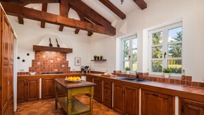 A kitchen with wooden cabinets, a central island, and a large window.
