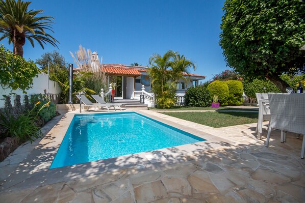 A rectangular swimming pool with a stone deck, surrounded by palm trees and a well-maintained lawn. - Top modern penthouse, heated pool, garden, beach within walking distance, parking space (Puerto de la Cruz)
