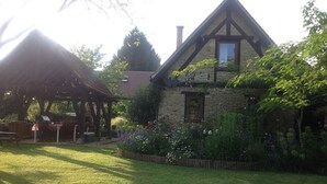 A stone house with a gabled roof and a wooden deck. - Charming Individual cottage" La Petite Grange" for maximum 4 people   (Puybrun)