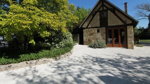 A stone building with a pitched roof and a gravel driveway. - Charming Individual cottage" La Petite Grange" for maximum 4 people   (Puybrun)