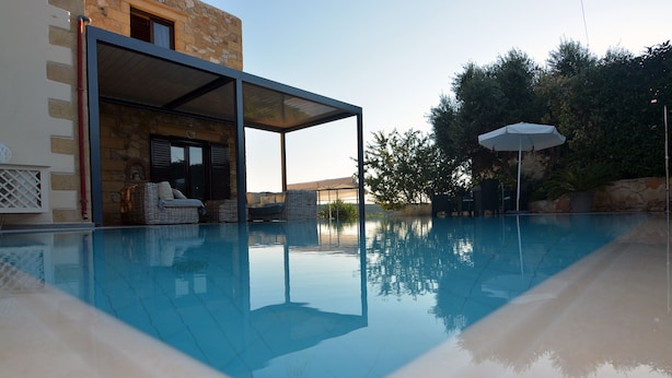 A swimming pool with a covered seating area, stone walls, and a view of the surrounding landscape. - Sea-view villa, 1.5 km from beaches, private heated pool (optional). (KONTOMARI)