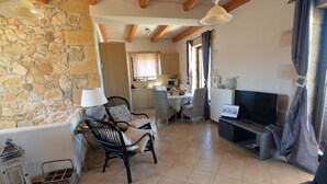A cozy living room with stone walls, a fireplace, a TV, and comfortable seating. - Sea-view villa, 1.5 km from beaches, private heated pool (optional). (KONTOMARI)