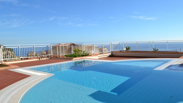 A rooftop swimming pool with a clear view of the city skyline in the background. - AMAZING APARTMENT LOFT NEAR THE BEACHES (Cap-D'ail)