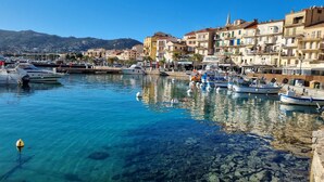 A marina with boats docked, clear water, and buildings with balconies. - Stunning 82m² air-conditioned 4-bedroom apartment in a villa in Calvi (Calvi)