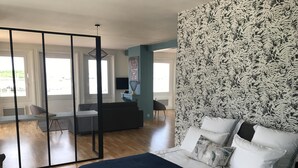Une chambre à coucher moderne avec un grand lit, un bureau et un canapé.