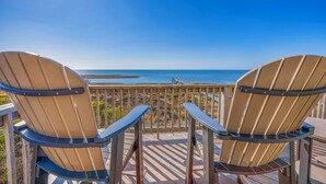 Two Adirondack chairs facing a wooden deck with a view of the ocean. - Sweet Tranquility – Soundfront Retreat w/ Pool, Hot Tub, Game Room & Tiki Bar (Salvo)