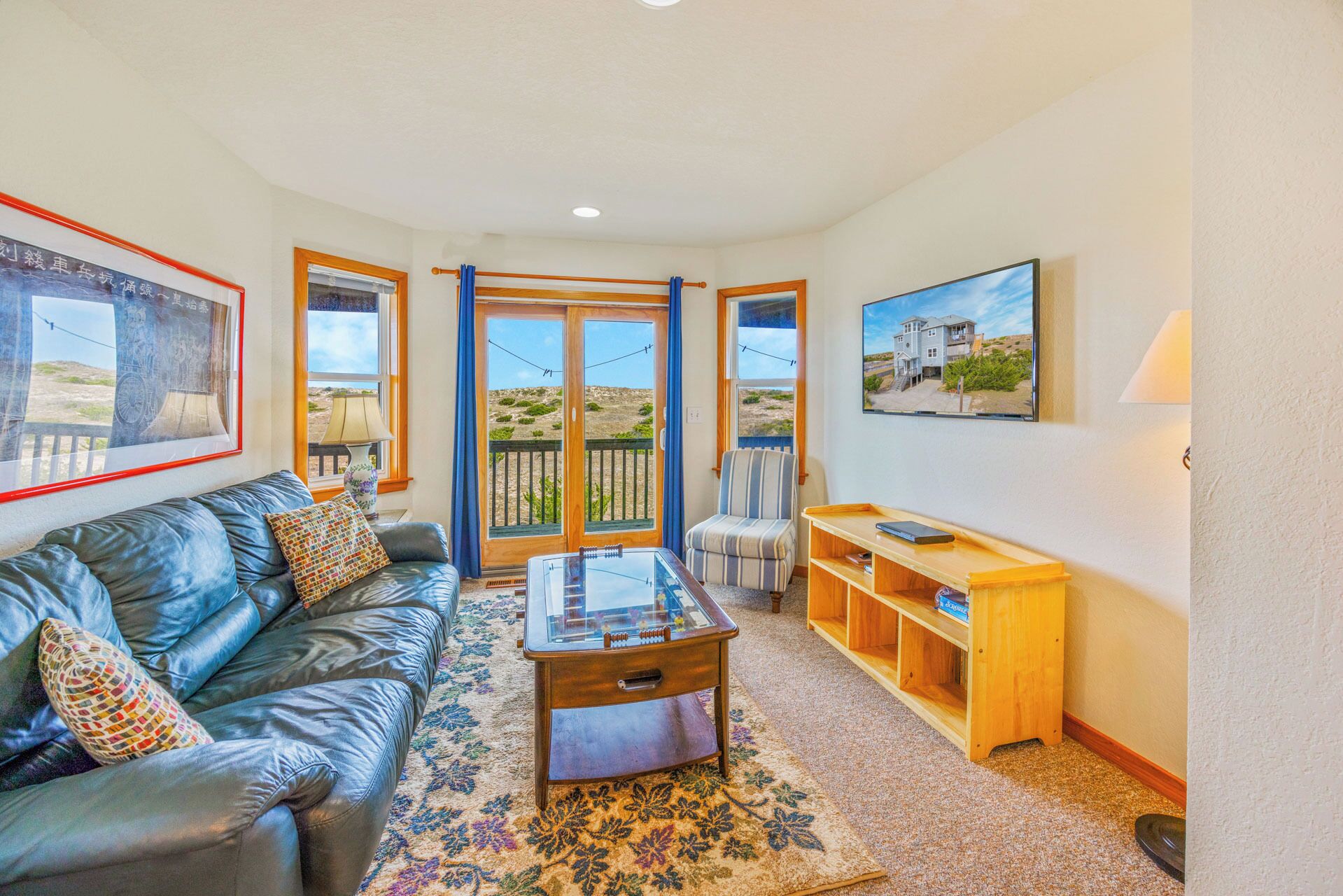 A cozy living room with a leather sofa, a glass-top coffee table, and a wooden side table.