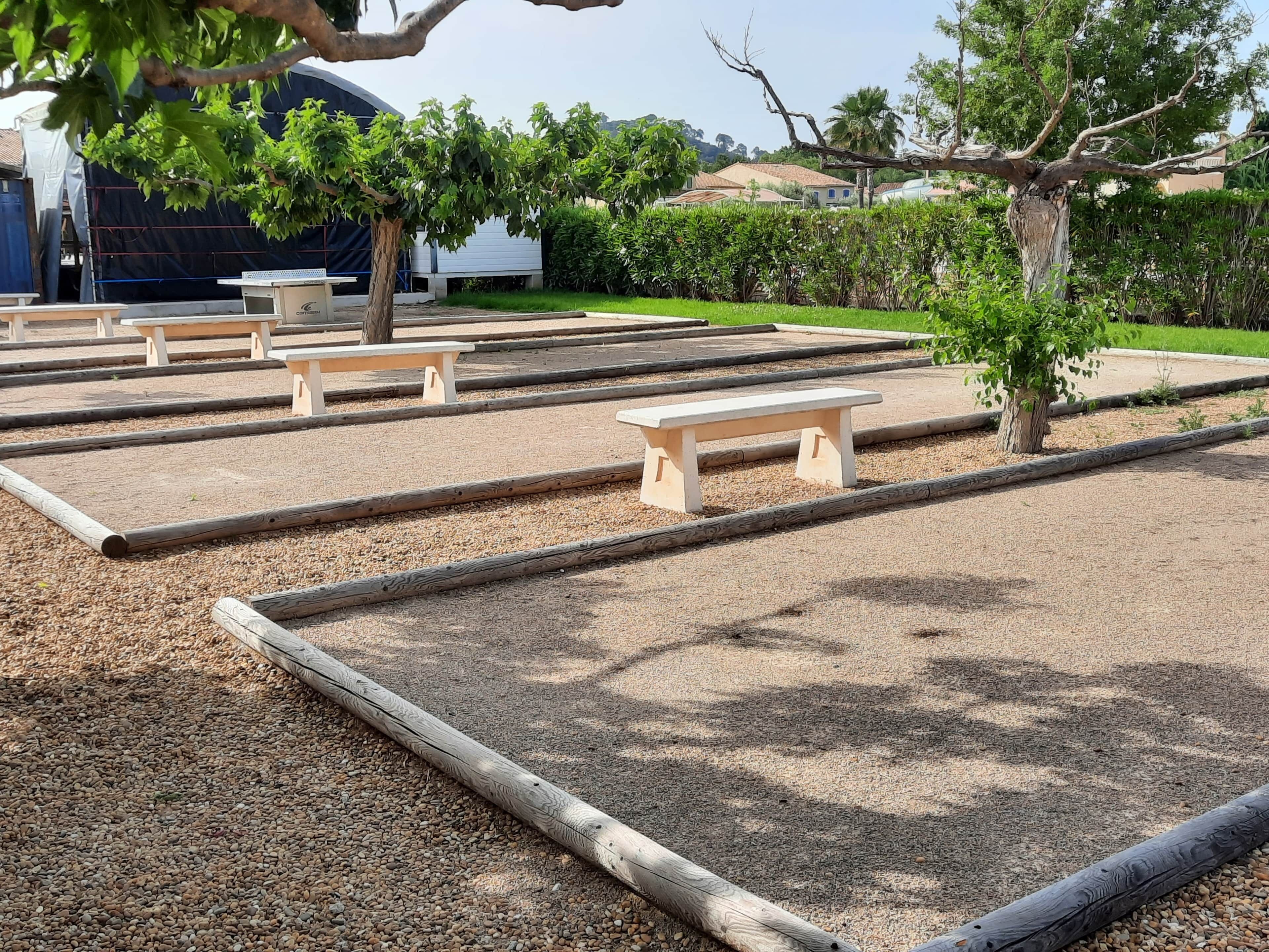 Un espace jardin aménagé avec plusieurs bancs en bois et un chemin de gravier.