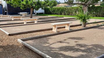 Un espace jardin aménagé avec plusieurs bancs en bois et un chemin de gravier.