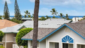 A residential area with houses, palm trees, and a view of the ocean. - 🌴Lovely quiet location partial ocean views.This complex requires a 30 day minimum stay.🌴 (Kailua Kona)