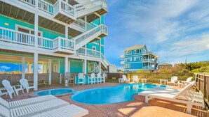 A pool area with multiple lounge chairs and a pool. - Premier Soundfront Dog Friendly w/ Pool, Hot Tub, Theater and Game Rooms, More (Hatteras)