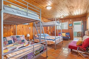 Ein Zimmer mit Etagenbetten, einer Schlafcouch und einem kleinen Tisch.