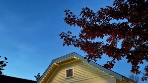 A single-story house with a front porch, a picket fence, and a well-maintained lawn. - East End Cottage, History meets Luxury. (Boise)