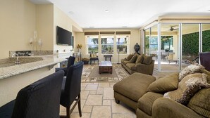 A spacious living area with a kitchen counter, seating, and a large sliding glass door leading to an outdoor patio. - #1 choice in PGA, WOW 3 master bedrm,Huge Private Lot! GR8 Views golf/mt #067336 (La Quinta)