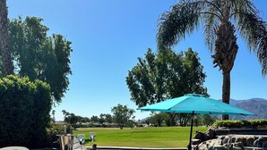 A poolside area with lounge chairs, a tiki bar, and a view of a golf course. - #1 choice in PGA, WOW 3 master bedrm,Huge Private Lot! GR8 Views golf/mt #067336 (La Quinta)