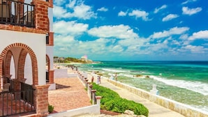 A coastal hotel with a brick facade, a balcony, and a view of the ocean. - Ocean View Villa "Saltillo" with a/c and 2 pools, 5 min stroll to beach (Isla Mujeres)
