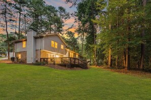 A two-story house with a covered porch and a wooden deck.