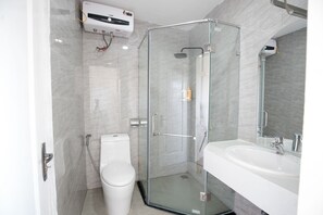 A modern bathroom with a glass-enclosed shower, a white sink, and a toilet. - City View Apartment Easternstay (Hanoi)