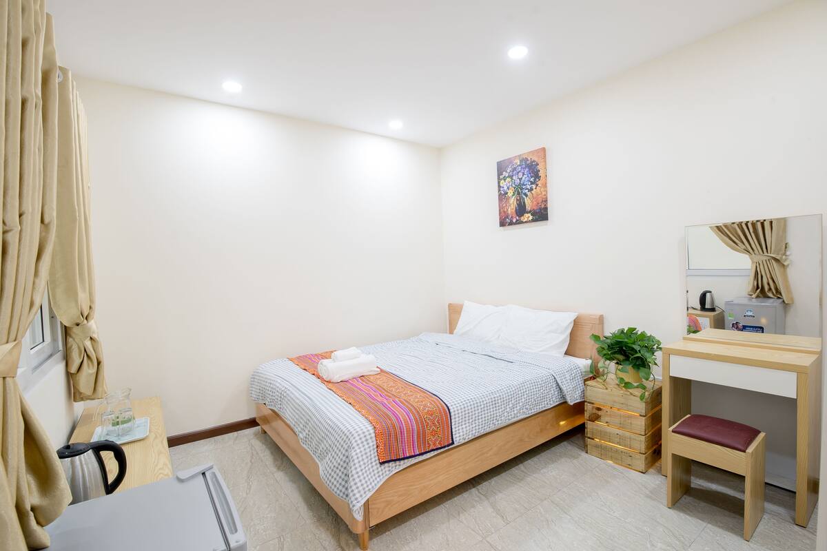 Una camera da letto con un letto, un comodino, una cassettiera e uno specchio.