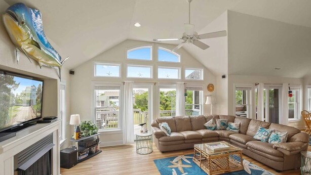A spacious living room with a large sectional sofa, a fireplace, and a view of the outside.