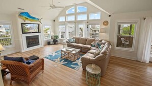 A spacious living room with a large sectional sofa, a fireplace, and a television.