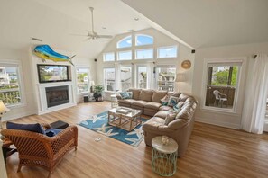 A spacious living room with a large sectional sofa, a fireplace, and a television.